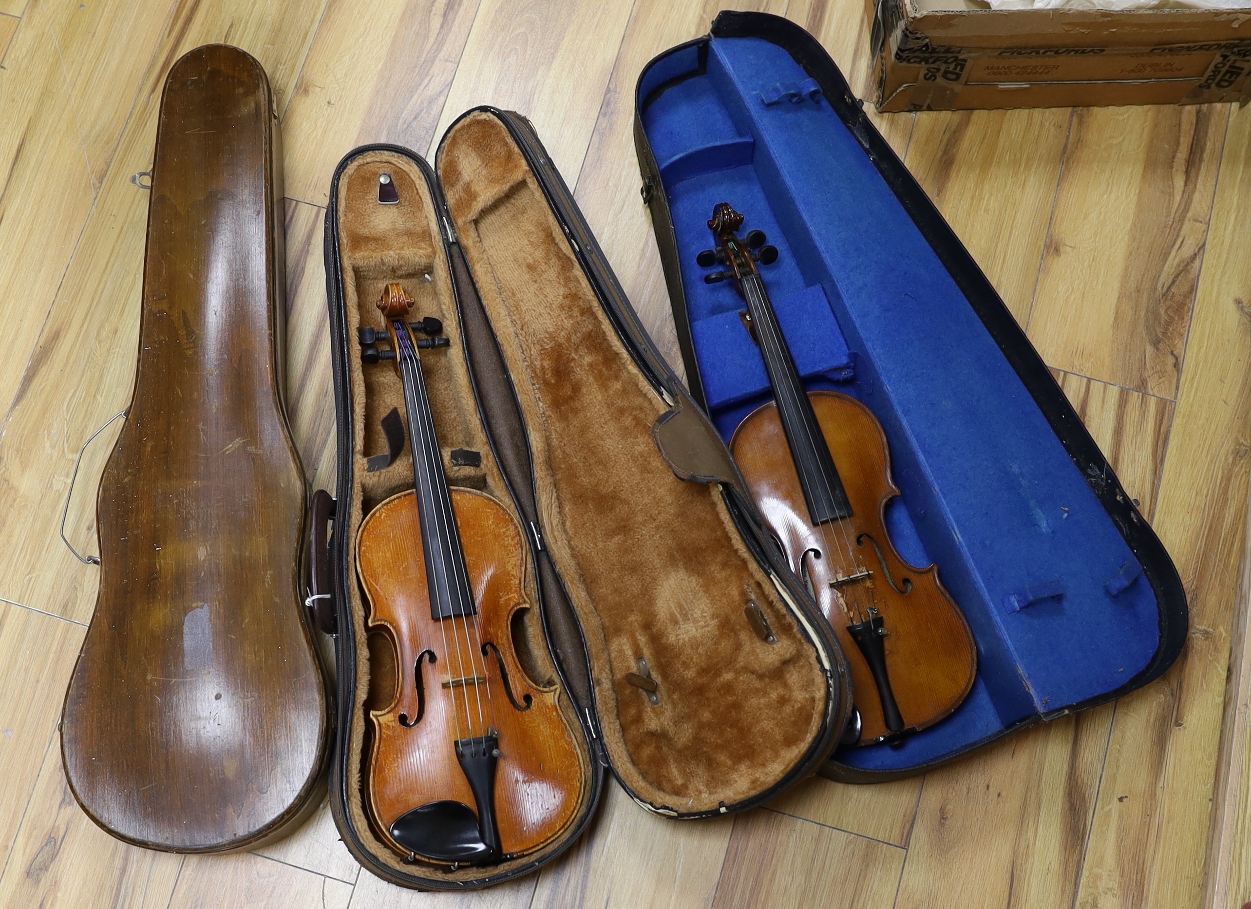 Two cased three quarter size violins, one labelled the London violin co Ltd, length of back 33.5 cm together with a wooden violin case